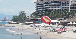 Vendedores de playa en Puerto Vallarta reportan ventas regulares este verano, con turistas regateando sus productos